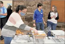  ?? Peyton elliott ?? Lydia Hyde (left) sets up warm crescent rolls for the 33rd annual Thanksgivi­ng Love Feast at the Rome Civic Center.