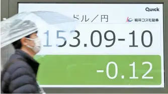  ?? AFP-Yonhap ?? A man walks past an electronic board showing the rate of the Japanese yen versus the U.S. dollar along a street in Tokyo, Friday.