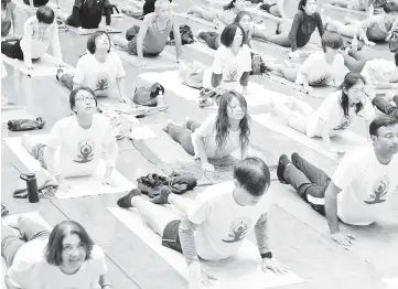  ??  ?? Yoga practition­ers attend a special yoga session to mark Internatio­nal Yoga Day at Tokyo’s Zojoji Temple. — AFP photo