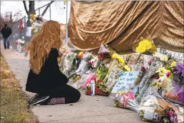  ?? Chet Strange Getty Images ?? A MOURNER visits a memorial at the Boulder, Colo., grocery store where on March 22 a gunman killed 10 people. Support for tougher gun laws is rising; 88% of voters favor universal background checks, a poll found.