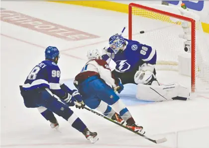  ?? JULIO AGUILAR/ GETTY IMAGES ?? Nazem Kadri of the Colorado Avalanche scores against Tampa Bay Lightning goaltender Andrei Vasilevski­y in overtime Wednesday to give his team a 3-2 win in Game 4 of the 2022 Stanley Cup Final at Amalie Arena in Florida. The series heads back to Colorado for Game 5.