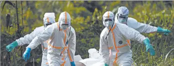  ?? JEROME DELAY/AP ?? Burial workers in protective gear carry the remains of an Ebola-infected person July 14 in Congo, where an outbreak has infected more than 3,000 people and killed nearly 2,000.