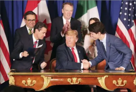  ?? MARTIN MEJIA — THE ASSOCIATED PRESS ?? President Donald Trump, center, shakes hands with Canada’s Prime Minister Justin Trudeau as Mexico’s President Enrique Pena Nieto looks on after they signed a new United States-Mexico-Canada Agreement that is replacing the NAFTA trade deal, during a ceremony Friday at a hotel before the start of the G20 summit in Buenos Aires, Argentina.
