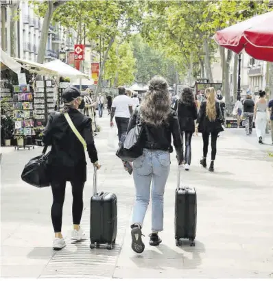  ?? Ricard Cugat ?? Dos turistas arrastran sus maletas por la Rambla el 31 de mayo, un escena inédita durante la pandemia.