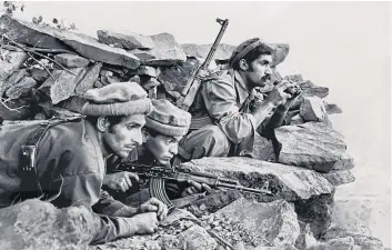  ??  ?? Close to the action: Steve McCurry shot to fame after his picture of mujahideen observing a Russian convoy in Nuristan was published in The New York Times in 1979