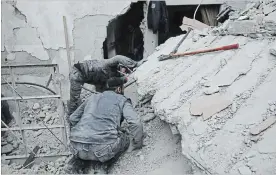  ?? SYRIAN CIVIL DEFENCE ASSOCIATED PRESS FILE PHOTO ?? A member of the White Helmets searches for victims under the rubble of a destroyed house in Ghouta, a suburb of Damascus, Syria.