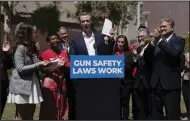  ?? (AP/Jae C. Hong) ?? California Gov. Gavin Newsom (center) celebrates Friday at Santa Monica College campus in Santa Monica, Calif., after singing a gun control law. Newsom is surrounded by state officials including state Sen. Bob Hertzberg (right), state Sen. Anthony Portantino (second right), Attorney General Rob Bonta (third left) and gun violence survivors, Mia Tretta and Arvis Jones.