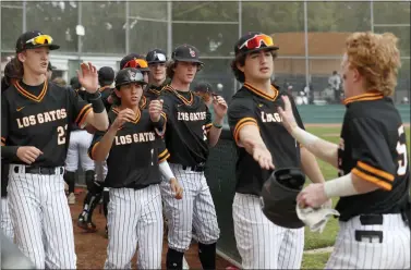  ?? ?? ABOVE: Los Gatos's Drew Dillehay, right, gets a warm dugout welcome after knocking in a run during a 4-3 victory against Westmont High in Campbell on March 18.