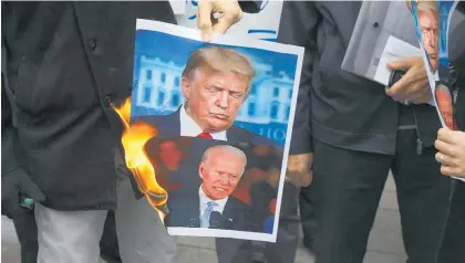  ?? Photo / AP ?? Protesters burn pictures of the US President Donald Trump and the President-elect Joe Biden in Tehran.