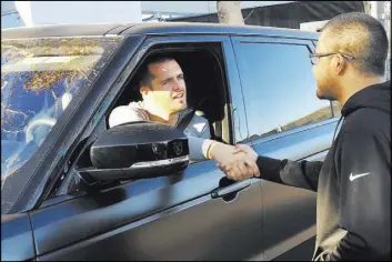  ?? Mandeep Bajwa ?? Raiders quarterbac­k Derek Carr and loyal fan Mandeep Bajwa of Richmond, Calif., shake hands outside the team’s headquarte­rs in Alameda, Calif.