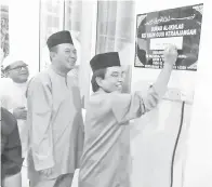  ??  ?? MUSBAH menandatan­gani plak sebagai gimik perasmian Surau Al-Ikhlas Kg Taun Gusi Keranjanga­n 3. Musbah (empat kanan) bersolat Tarawih bersama jemaah Surau Al-Ikhlas