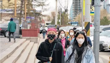  ?? KHASAR SANDAG/THE NEW YORK TIMES ?? Pedestrian­s in Ulaanbaata­r, Mongolia on May 12. Chinese-made vaccines had Mongolia promising its citizens a “COVID-free summer.” However, on June 20, the country recorded 2,400 new infections.