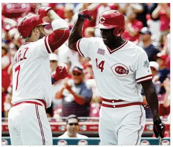  ?? JOE ROBBINS / GETTY IMAGES ?? Eugenio Suarez of the Cincinnati Reds (left) celebrates his first-inning solo home run against the St. Louis Cardinals with Aristides Aquino at Great American Ball Park on Sunday.