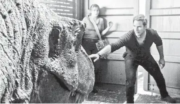  ??  ?? Claire (Howard) and Owen (Pratt, also below) try not to wake a T. rex in ‘Jurassic World: Fallen Kingdom’. — Courtesy of Universal Studios