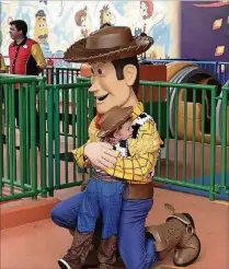  ?? PHOTO BY KATE TUCKWOOD-TAYLOR ?? Howdy, partner:Jack Crowley Edwards gives Sheriff Woody a big cowboy hug. Characters from the “Toy Story” movies, including the green army men, Jessie and Buzz Lightyear, patrol the new Toy Story Land.