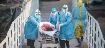  ?? by Xiao Yijiu/xinhua ?? February 4, 2020: Medical workers help the first batch of patients infected with the novel coronaviru­s move into their isolation wards at Huoshensha­n Hospital in Wuhan, Hubei Province.