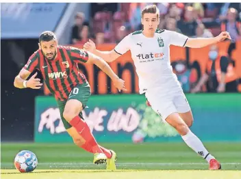  ?? FOTO: DPA/MATTHIAS BALK ?? Florian Neuhaus (r.), hier im Bild mit Daniel Caligiuri vom FC Augsburg, hat das Rennen um die Startelf vorerst gegen Manu Koné verloren.