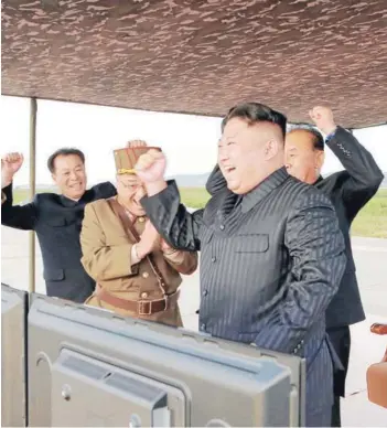  ??  ?? ► Kim festeja el lanzamient­o de un misil Hwasong-12, en septiembre pasado.