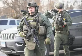  ??  ?? Armed police officers deploy near where the active shooter was reported at the Henry Pratt Co. in Aurora, Ill., about 40 miles west of Chicago.