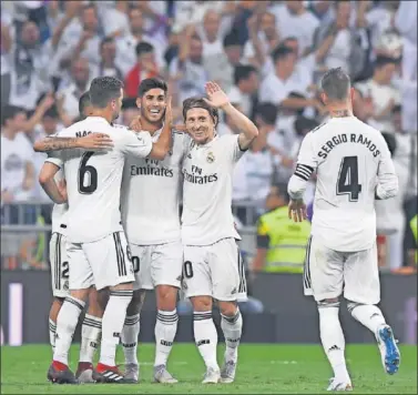  ??  ?? UN GOL QUE VALIÓ TRES PUNTOS. Ceballos, Nacho, Modric y Ramos abrazaron a Asensio por su gol.