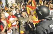  ?? FRANCISCO SECO — THE ASSOCIATED PRESS ?? Demonstrat­ors challenge Catalan Mossos d’Esquadra regional police officers at the end of a march in downtown Barcelona, Spain, on Sunday.