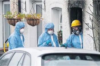  ?? ?? EVIDENCE: Fire investigat­ors at the scene in Sutton where two sets of twin boys died.