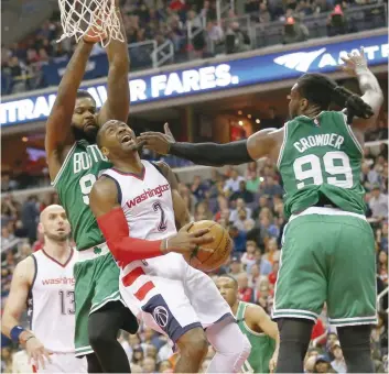  ?? — USA Today Sports ?? Washington Wizards guard John Wall (2) shoots the ball as Boston Celtics forward Jae Crowder (99) and Celtics forward Amir Johnson (90) defend in the fourth quarter in game six of the second round of the 2017 NBA Playoffs at Verizon Center. The Wizards...