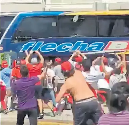  ?? IMAGEN TV ?? La locura. El micro de Boca es atacado por hinchas a 200 metros del Monumental. ¿Y la seguridad?