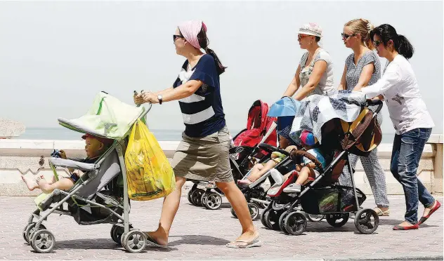  ?? Kamal Kassim, Gulf Today ?? A group of young mothers carry their babies in trolleys as they take a walk.