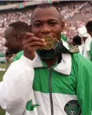  ?? Photograph: Popperfoto//BTS ?? Nigeria’s match-winner, Emmanuel Amunike, kisses his gold medal in Atlanta.