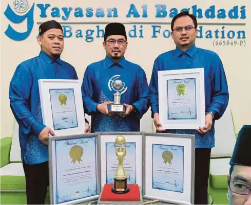  ??  ?? JALALUDDIN (tengah) bersama sijil dan piala pencapaian syarikat di pejabatnya.