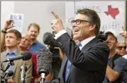  ?? AMERICAN-STATESMAN 2014 ?? Texas Gov. Rick Perry points to supporters near the Travis County criminal justice center before turning himself in on criminal charges in August 2014.