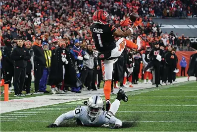  ?? AP Photo/Jeff Dean ?? Cincinnati Bengals' Ja'Marr Chase (1) makes a catch against Las Vegas Raiders' Desmond Trufant (10) during the first half of an NFL wild-card playoff football game Saturday in Cincinnati.