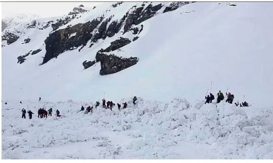  ??  ?? Working against time: Rescuers on the site of an avalanche working to find trapped skiers above the ski resort of CransMonta­na in the Swiss Alps. — AFP