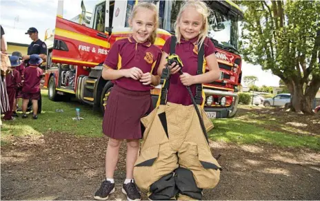  ?? Photos: Kevin Farmer ?? BIG SMILES: Maddison Matthews (left) and Nevaeh Muller have fun at the Queensland Fire and Rescue Service display.