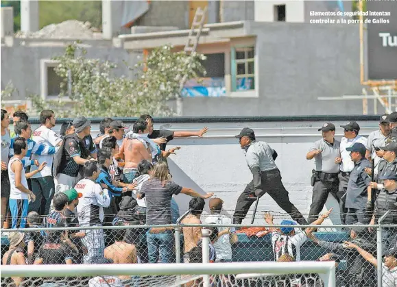  ??  ?? Elementos de seguridad intentan controlar a la porra de Gallos