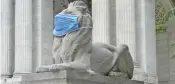  ?? — AFP ?? A marble lion at the New York Public Library, wears a mask to encourage New Yorkers to continue to follow safety measures in the fight against Covid-19.