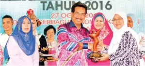  ??  ?? MUSA menyampaik­an trofi Anugerah Persatuan Wanita Cemerlang 2016 kepada Ainalmarha­nim.