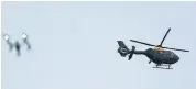  ??  ?? Top to bottom: Specialist firearms officers were at the scene; people being led away from Bermuda Park and (above) a drone and a police helicopter hover over the area