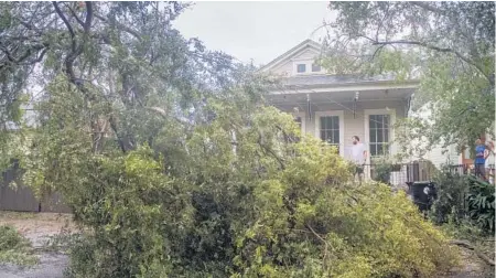  ?? CHRISGRANG­ER/AP ?? People look at a downed part of a tree after Hurricane Zetamade landfallWe­dnesday inNewOrlea­ns. Atropical depression in the Caribbean is expected to becomea hurricane by the time it is projected to hit the Central American coast.