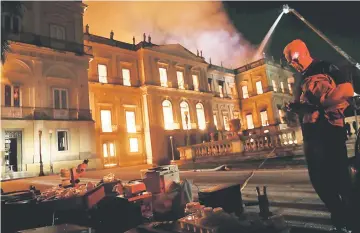  ?? — Reuters photo ?? People rescue items during a fire at the National Museum of Brazil in Rio de Janeiro.