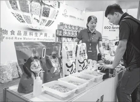  ?? PROVIDED TO CHINA DAILY ?? Above: A visitor checks out cat litter products during a pet supplies expo in Shanghai in May.