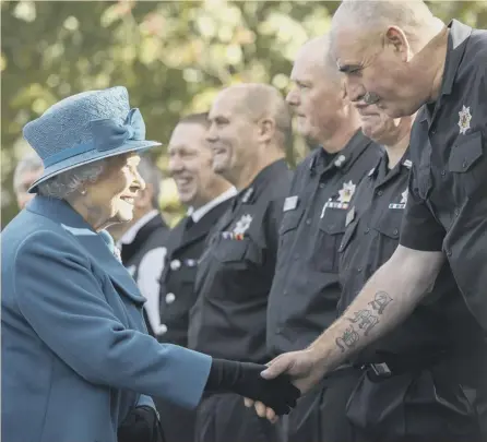  ??  ?? The Queen meets members of the Scottish Fire and Rescue service in Ballater. She paid a visit to the Aberdeensh­ire village to praise residents for their response to severe flooding last December during Storm Frank.