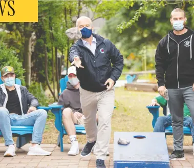  ?? RYAN REMIORZ / THE CANADIAN PRESS ?? Conservati­ve Leader Erin O'Toole plays a game of bean bag toss while campaignin­g at a drug rehab centre on Sunday
in New Westminste­r, B.C. O'Toole and his campaign workers and volunteers are always masked in public.