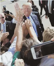  ?? AP PHOTO ?? GLAD-HANDING: President Trump high-fives supporters yesterday at Love Field airport in Dallas.