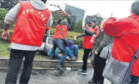  ?? SAM YEH / AFP ?? Choques. Un partidario de la unificació­n de China golpea a un independen­tista durante los actos de ayer en Taipéi. Abajo, la estatua de Chang Kai Chek
