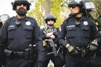  ?? Noah Berger / Special to The Chronicle ?? Police officers stand by as protesters face off April 15 in Berkeley. Officials changed the municipal code Friday to give the city manager the ability to issue rules at unauthoriz­ed events.