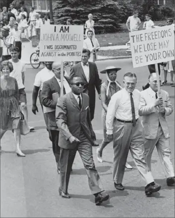  ??  ?? MICHIGAN GOV. GEORGE ROMNEY, second from right, joins a 1963 anti-segregatio­n march in the white suburb of Grosse Pointe. Supporters called him “Judas,” but he pressed ahead with a civil rights agenda.