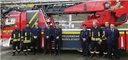  ??  ?? Kameraden der Rudolstädt­er Feuerwehr stehen vor dem neuen Fahrzeug mit der Drehleiter. Foto: Frank Michael Wagner