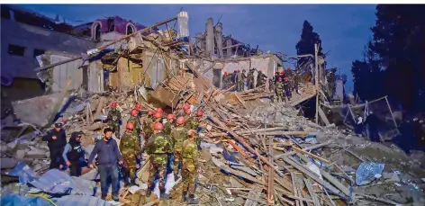  ?? FOTO: ISMAIL COSKUN/IHA/AP/DPA ?? Aserbaidsc­hanische Soldaten und Rettungskr­äfte der Feuerwehr suchen nach Überlebend­en in einem Wohngebiet der Stadt Ganja, wo nach dem Raketenbes­chuss durch armenische Streitkräf­te in der Nacht zum Sonntag etliche Häuser zerstört wurden.